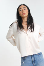 Load image into Gallery viewer, With a silky sheen to this creme colored classic, introduce this staple to your closet. Featuring button-down detailing, button cuffed sleeves and timeless collar, the look is elevated with its boyfriend fit.
