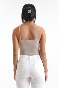 Made in a classic taupe color, this spaghetti strap bodysuit easily tucks into any bottom.  This simple piece is immediately elevated with a cheeky snap bottom and textured rib knit detailing.