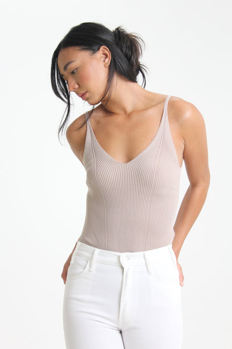 Made in a classic taupe color, this spaghetti strap bodysuit easily tucks into any bottom.  This simple piece is immediately elevated with a cheeky snap bottom and textured rib knit detailing.